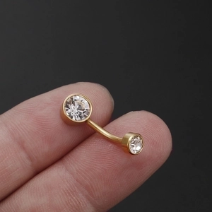 Titanium steel belly button ring with sparkling zircon held between two fingers