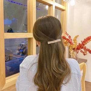 Handwoven crystal beaded spring hair clip in champagne gold shown on a model's hair