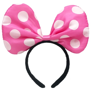Detailed view of the oversized pink polka dot bow headband with non-slip black texture