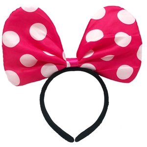 Detail of pink satin headband with white polka dots featuring a large Minnie-style bow