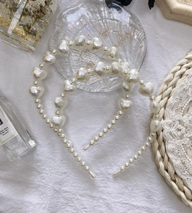 Detail of pearlescent heart-shaped beads and white faux pearls on elegant headbands