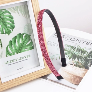 Detail shot of pink glitter headband with non-slip inner teeth on a rustic wooden background