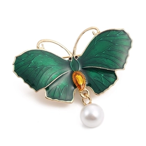 Elegant gold butterfly brooch with green enamel wings, yellow gemstone, and pearl pendant