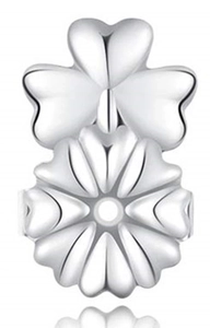 Macro shot of silver clover-shaped earring lifters with polished metallic finish