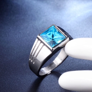 Macro shot of men's titanium steel ring with blue square gemstone and grooved details