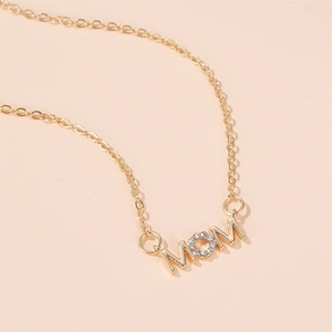 Élégant collier MOM en or avec pendentif O serti de diamants sur fond abricot doux