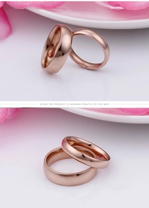 Detailed view of polished rose gold couple rings with minimalist smooth finish surface
