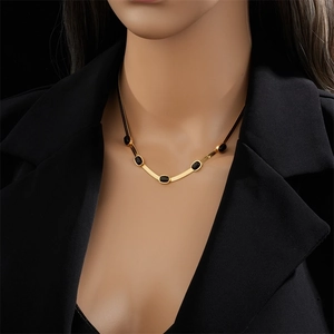 Elegant gold-plated snake chain necklace with oval black gemstones on a mannequin