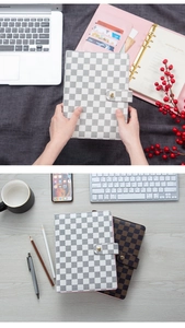 Macro detail of A5 leather binder with checkered pattern and functional card slots