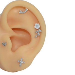 Stainless steel stud earring set with heart, cross, and floral zircon designs on ear model
