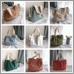 Nine candy-colored canvas drawstring handbags displayed in a minimalist grid arrangement
