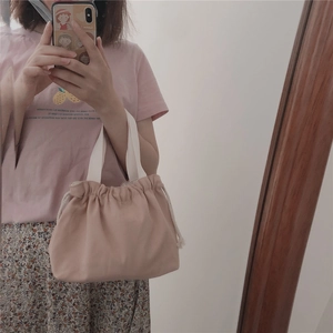 Mirror selfie showing the pink drawstring canvas handbag with white handles in daily use