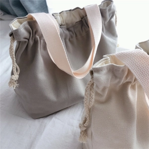 Detail of cotton canvas handbag showing drawstring closure and soft pink cotton handles