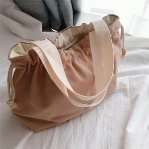 Detail of dusty rose canvas tote bag featuring thick fabric and cream drawstring closure