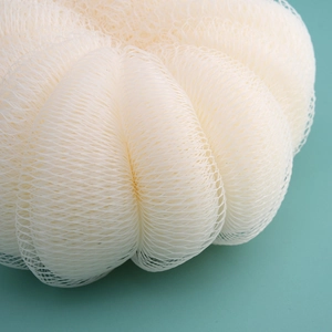 Close-up of fluffy off-white mesh bath sponge ball showing soft texture and netting