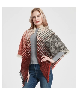 Detail of herringbone knit shawl with red and grey plaid pattern and fringe edges