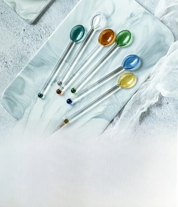 Vista macro di cucchiai colorati in vetro borosilicato su una superficie di marmo