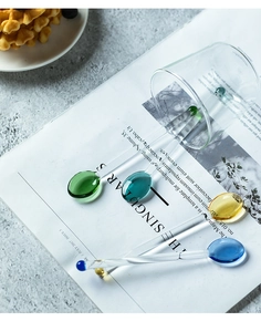 Primo piano di cucchiai in vetro termoresistente in verde, verde acqua, giallo e blu