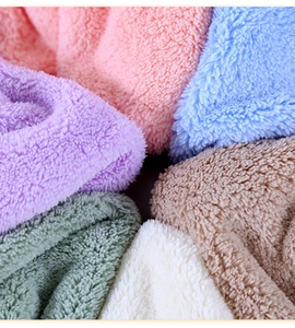 Close-up of soft coral fleece bath towels showing thick plush texture and multi-color stack