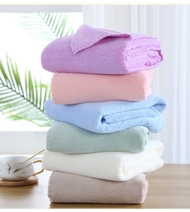 Folded soft coral fleece bath towels in purple, pink, blue, green, beige and brown