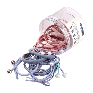 Pink and blue elastic hair tie set with pearls and beads falling from a clear storage jar