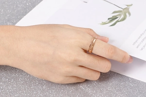 Detail showing geometric rhombic matte finish ring worn on hand in rose gold titanium steel