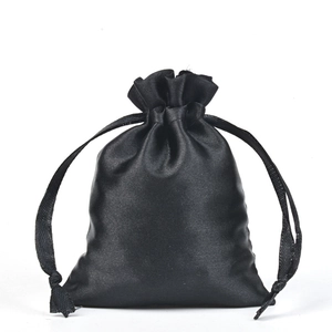 Close-up of black satin drawstring pouch showing smooth texture and glossy silk finish