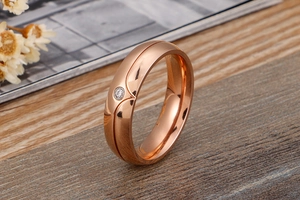 Detailed view of rose gold titanium ring featuring a heart engraving and a single diamond