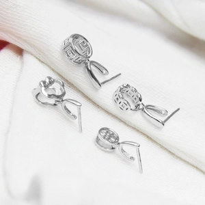 Macro view of four S925 sterling silver pinch bails with hollow patterns for DIY pendants