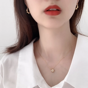 Detail of 925 silver gold star necklace and hoop earrings on a model with white shirt