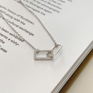 Macro detail of interlocking rectangular pendants with zircon inlay on a silver chain