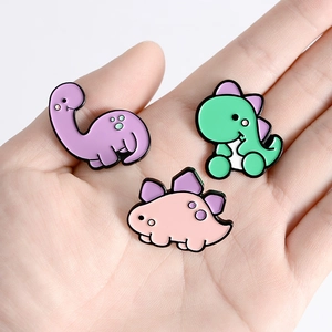 Ensemble de trois épingles en émail de dinosaures colorés en violet, vert et rose