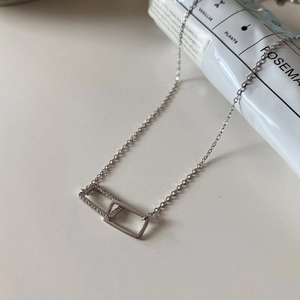 Detailed close-up of interlocking rectangular silver pendants with sparkling zircon stones