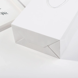 Sacchetto regalo minimalista in carta bianca con manici in cotone per abbigliamento