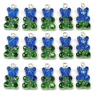 Macro shot of 15 glittery blue and green resin gummy bear charms with metal rings