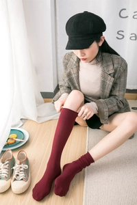 Detail view of burgundy cotton knit knee-high socks with vertical ribbed texture