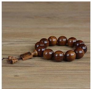 Vue macro du grain de bois naturel des perles Huanghuali avec une plaque en bois sculpté