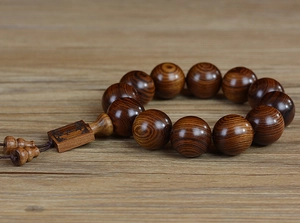 Détail macro des perles en bois de poirier jaune avec grain naturel et pendentif sculpté