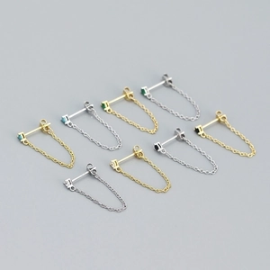 Detailed view of silver and gold chain earrings with colorful cubic zirconia stones