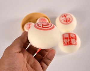 Détail d'un jouet bun squishy ivoire avec sceau rouge et texture à rebond lent