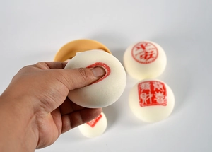 Détail de jouet antistress en mousse PU brioche vapeur avec caractères rouges