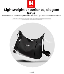 Detail view of lightweight black nylon crossbody crescent bag with metal zipper and logo