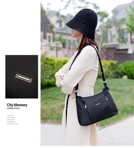 Detail of black nylon crossbody bag featuring silver buckle and model street style view