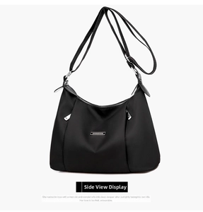 Detail view of black waterproof oxford fabric crossbody bag with silver hardware and logo