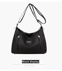 Close-up of black waterproof oxford cloth cross-body bag with rectangular metal logo