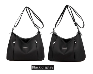 Detail view of black nylon hobo bag featuring silver hardware zippers and matte texture