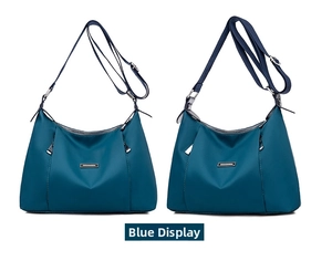 Front view of large capacity blue nylon crossbody bag with dual zipper compartments