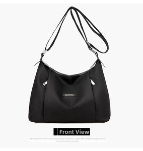 Front view of black nylon crossbody bag featuring silver metal trim and adjustable strap