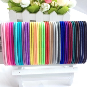 Macro shot of 3mm elastic hair ties in candy colors displayed on a card holder