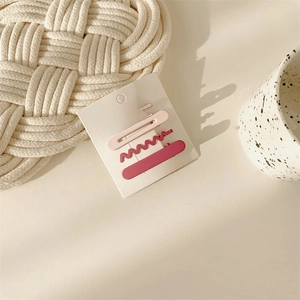 Detail of 4-piece set pink matte hair clips including wave and classic barrette styles